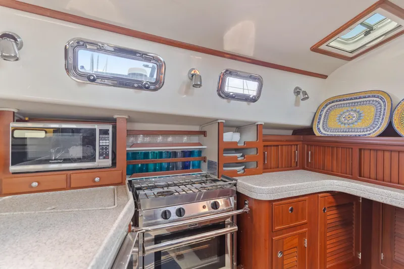 Resolute Yacht Photos Pics Luxurious 2015 Blue Jacket 40 yacht kitchen with stove, microwave, and elegant wood cabinetry.