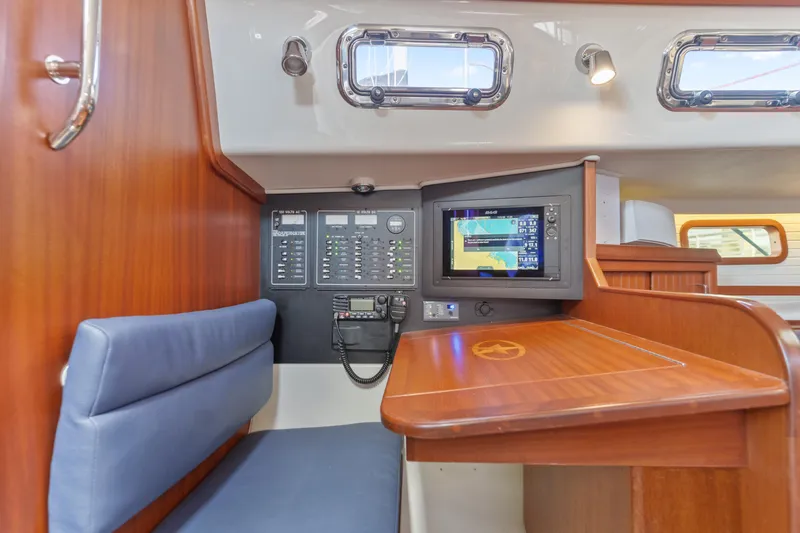 Resolute Yacht Photos Pics Navigation station inside 2015 Blue Jacket 40 sailboat, featuring control panel and seating.