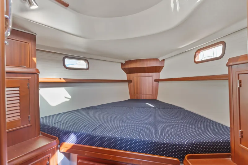 Resolute Yacht Photos Pics Cozy cabin interior of 2015 Blue Jacket 40 sailboat with wooden furnishings and a spacious bed.