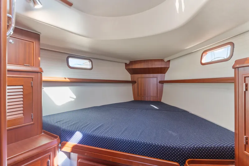 Resolute Yacht Photos Pics Cozy cabin interior of 2015 Blue Jacket 40 sailboat with wooden finish and porthole windows.