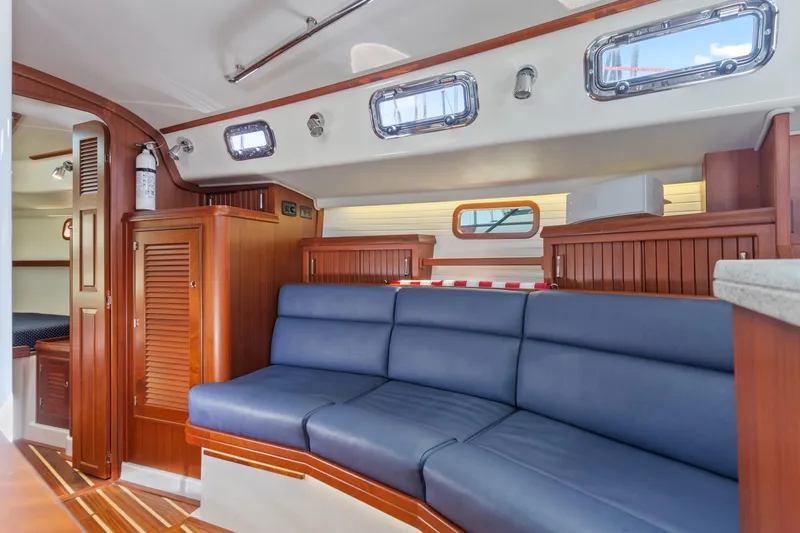 Resolute Yacht Photos Pics Interior of 2015 Blue Jacket 40 sailboat with blue seating and wooden cabinetry.