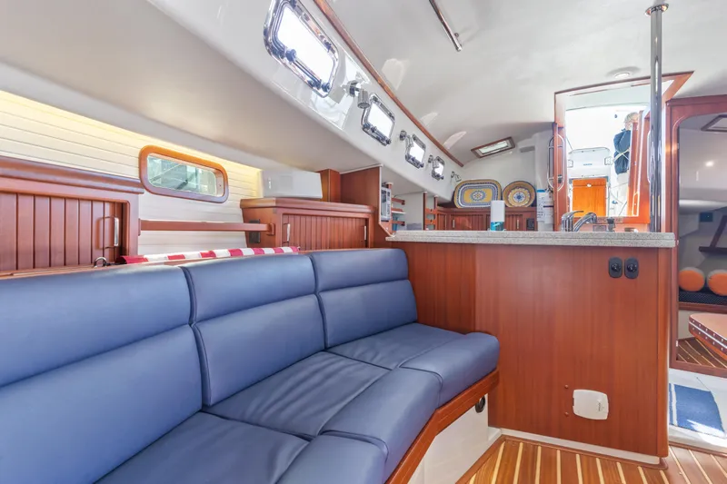 Resolute Yacht Photos Pics Interior of 2015 Blue Jacket 40 sailboat with blue seating and wooden accents.