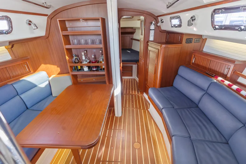 Resolute Yacht Photos Pics Interior of 2015 Blue Jacket 40 sailboat with wooden furnishings and blue seating.