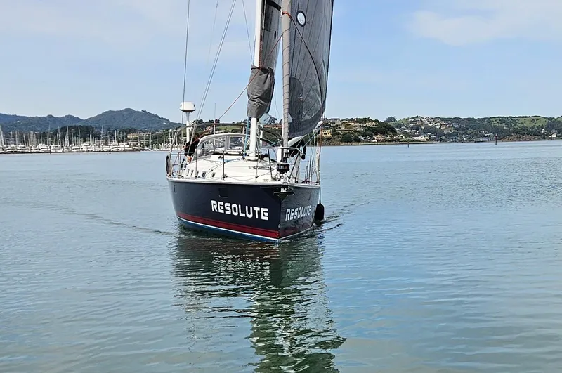 Resolute Yacht Photos Pics Sailboat "Resolute" on calm water, Blue Jacket 40 model, 2015, with scenic background.