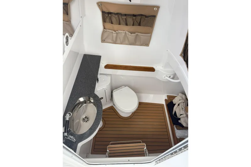  Yacht Photos Pics 2026 Southport 30 FE boat interior with sink, toilet, and wooden flooring.
