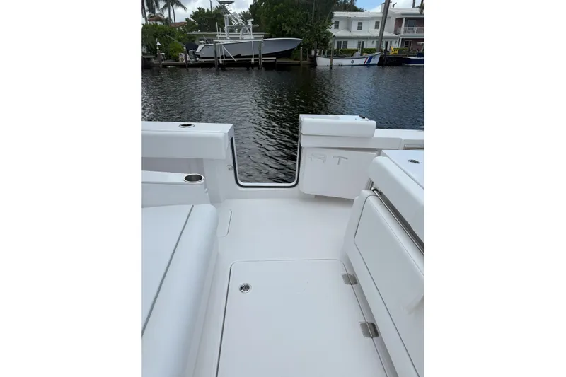  Yacht Photos Pics 2026 Southport 30 FE boat interior with white seating, docked by waterfront homes.