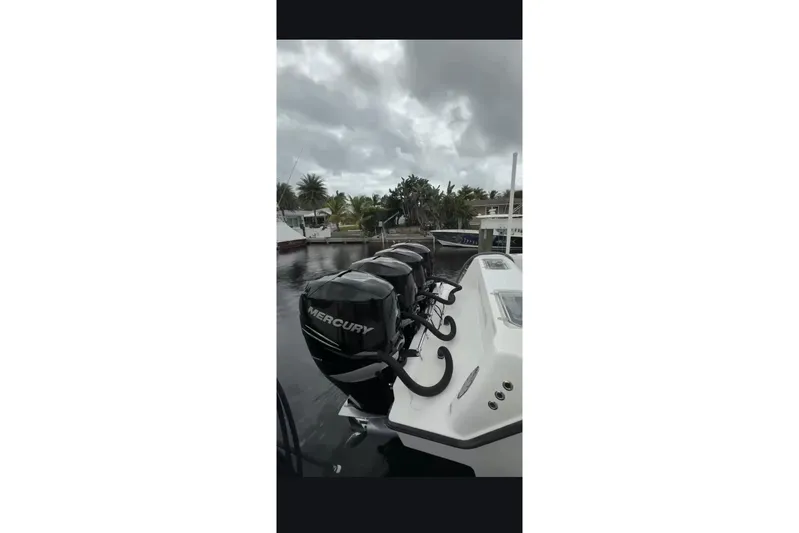  Yacht Photos Pics 2020 Contender 39 ST boat with multiple Mercury outboard engines docked by palm trees.