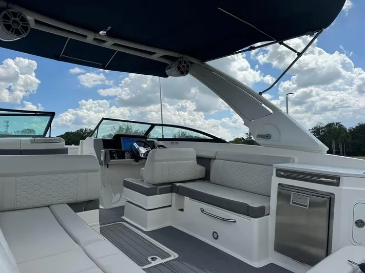  Yacht Photos Pics 2022 Sea Ray SDX 290 Outboard boat interior with seating and helm under a blue canopy.