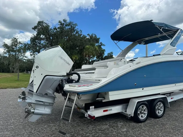  Yacht Photos Pics 2022 Sea Ray SDX 290 Outboard boat on trailer, blue and white design, under a cloudy sky.