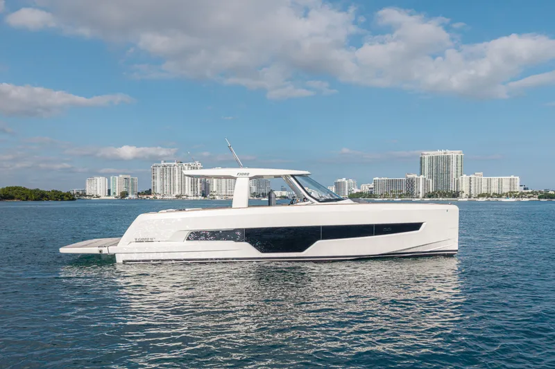 Improper Yacht Photos Pics 2024 Fjord 41 XL yacht cruising on water with city skyline in background.