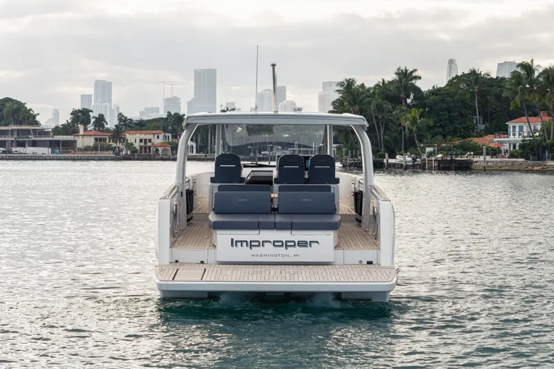 Improper Yacht Photos Pics 2024 Fjord 41 XL yacht on water, city skyline and palm trees in background.