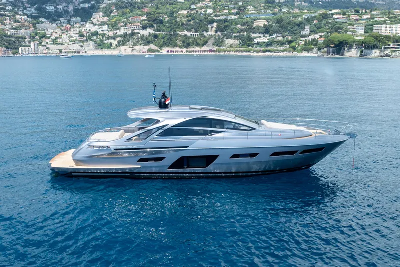 Ciao Yacht Photos Pics 2024 Pershing 7X yacht cruising on clear blue waters near a scenic coastal town.