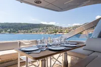 Luxurious dining setup on 2024 Pershing 7X yacht with scenic coastal view.