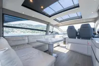 Luxurious interior of 2024 Pershing 7X yacht with panoramic windows and modern seating.