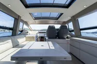 Luxurious interior of 2024 Pershing 7X yacht with panoramic windows and modern seating.