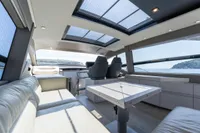 Luxurious interior of 2024 Pershing 7X yacht with panoramic windows and modern seating.