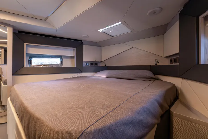 Ciao Yacht Photos Pics Luxurious bedroom interior of 2024 Pershing 7X yacht, featuring modern design and cozy bedding.
