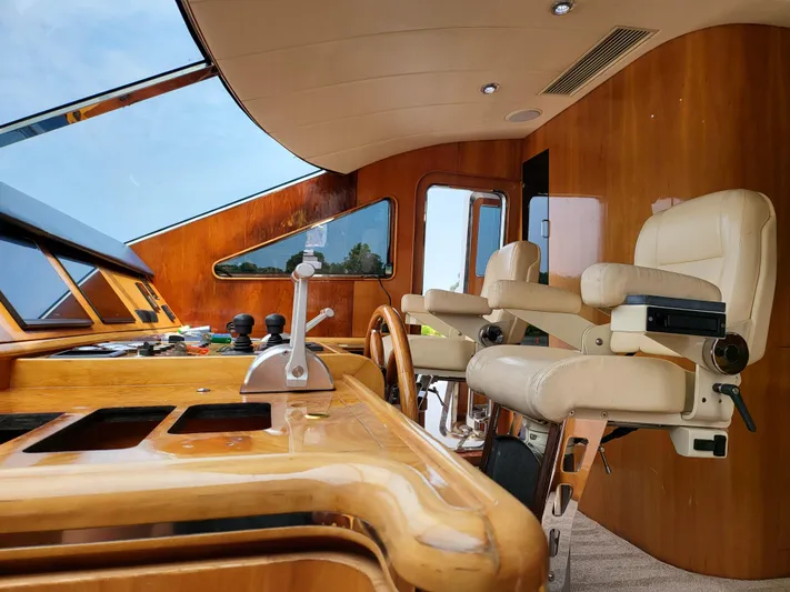  Yacht Photos Pics Interior helm of 2000 Horizon 74 Motor Yacht with luxurious seating and wooden dashboard.