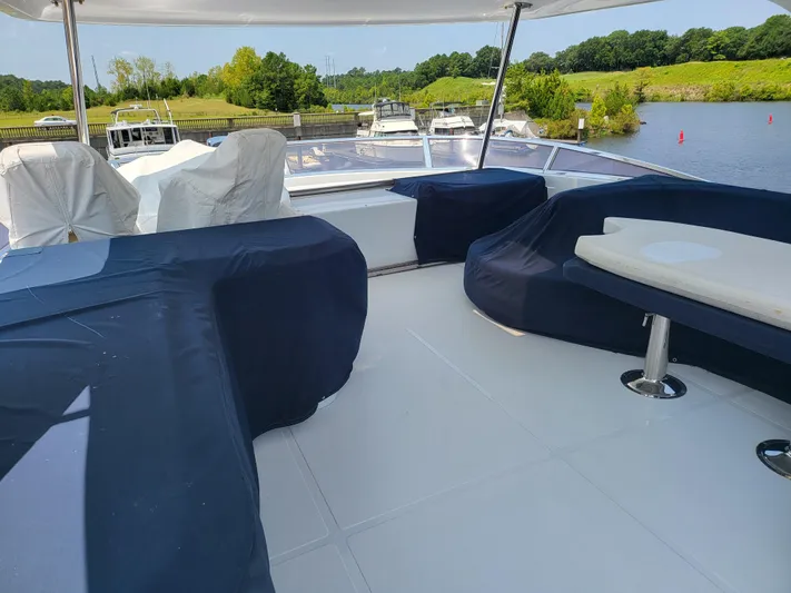  Yacht Photos Pics Spacious deck of 2000 Horizon 74 Motor Yacht with covered seating, docked by a scenic river.