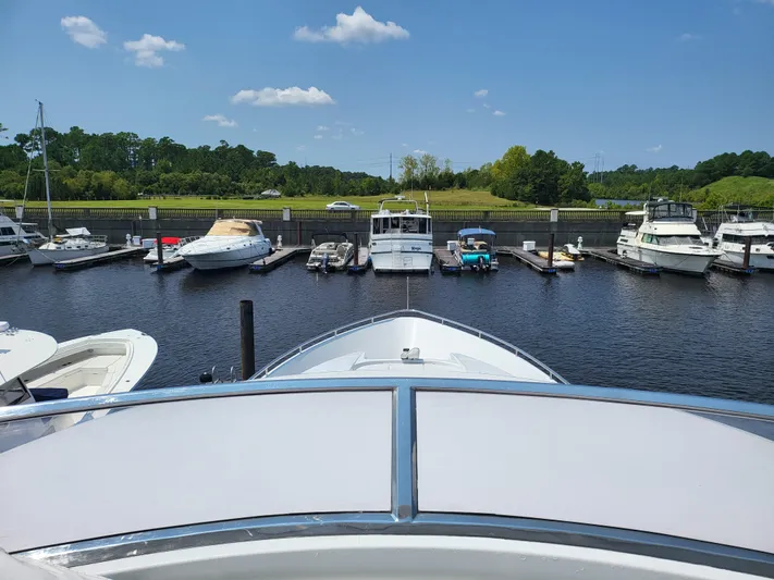  Yacht Photos Pics Bow view of a 2000 Horizon 74 Motor Yacht docked in a marina under a clear sky.