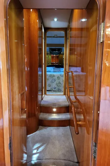 Yacht Photos Pics Interior hallway of 2000 Horizon 74 Motor Yacht with wooden finish and carpeted steps.