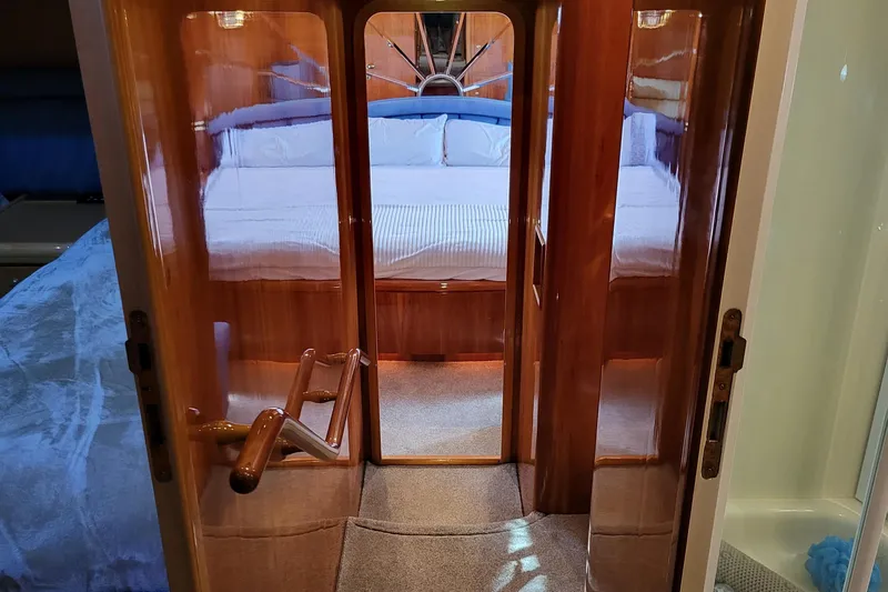  Yacht Photos Pics Luxurious cabin interior of 2000 Horizon 74 Motor Yacht with wooden finishes and cozy bedding.