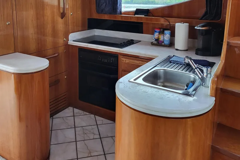  Yacht Photos Pics Kitchen area of 2000 Horizon 74 Motor Yacht with wooden cabinetry and modern appliances.