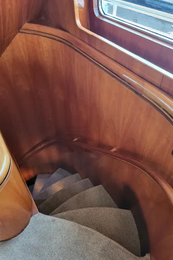  Yacht Photos Pics Curved wooden staircase inside 2000 Horizon 74 Motor Yacht, featuring elegant design and carpeting.