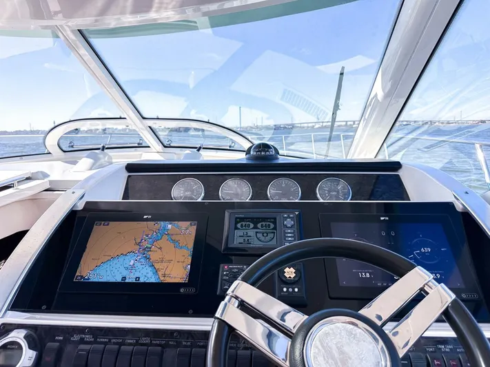 Wine Down Yacht Photos Pics Cockpit view of 2012 Sea Ray 450 Sundancer with navigation screens and steering wheel.