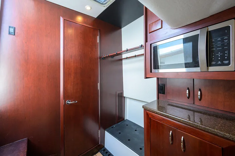 Tales N' Ales Yacht Photos Pics 2018 Buddy Davis 42 Center Console cabin with cabinetry and microwave.