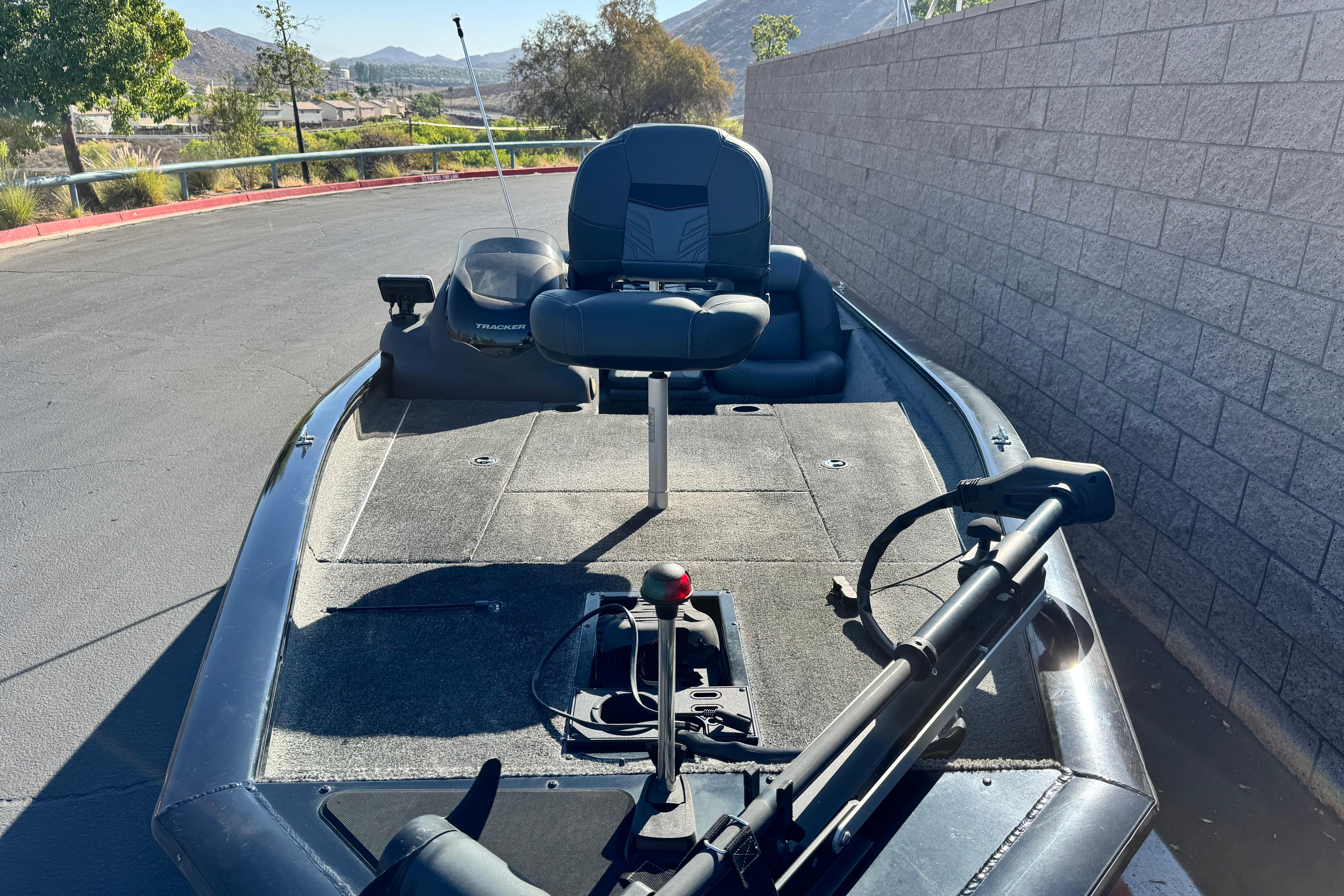 2019 Tracker Pro Team 175 boat parked on pavement, featuring a fishing seat and trolling motor.