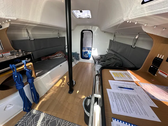 Rebel Yacht Photos Pics Interior of 2021 Jeanneau Sun Fast 3300 sailboat with seating, table, and nautical equipment.