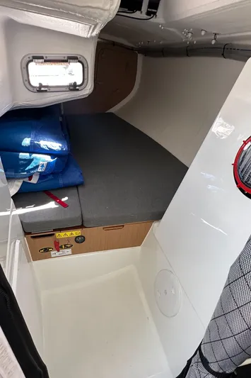 Rebel Yacht Photos Pics 2021 Jeanneau Sun Fast 3300 cabin interior with compact sleeping area and storage.