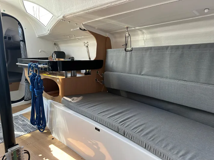Rebel Yacht Photos Pics Interior of 2021 Jeanneau Sun Fast 3300 sailboat with gray seating and wooden accents.