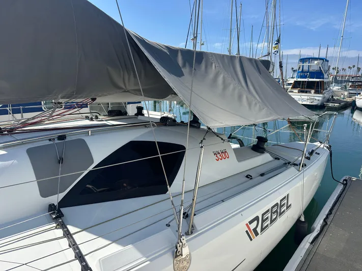 Rebel Yacht Photos Pics 2021 Jeanneau Sun Fast 3300 sailboat docked at marina, featuring "Rebel" branding.