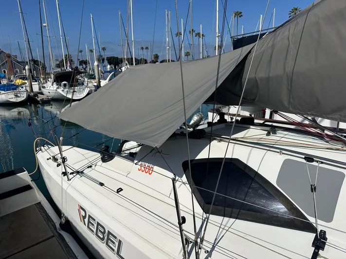Rebel Yacht Photos Pics 2021 Jeanneau Sun Fast 3300 sailboat docked at marina, covered with a tarp.