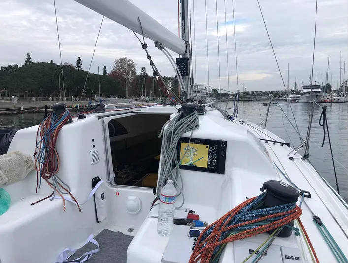 Rebel Yacht Photos Pics 2021 Jeanneau SUNFAST 3300 sailboat cockpit with ropes and navigation equipment in a marina.