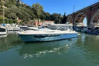 2023 Nimbus W11 boat docked in a scenic marina with a bridge in the background.
