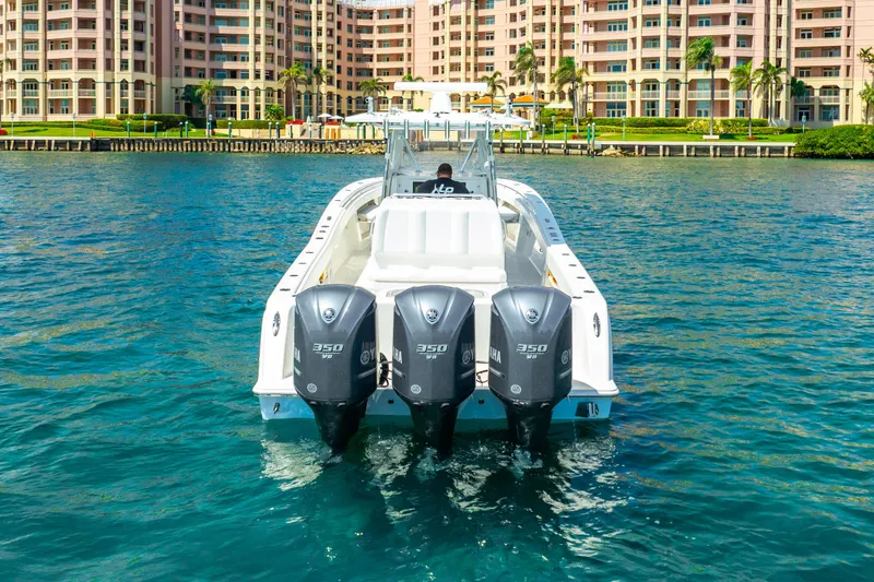  Yacht Photos Pics 2016 Invincible 39 boat with triple engines on water, near waterfront buildings.