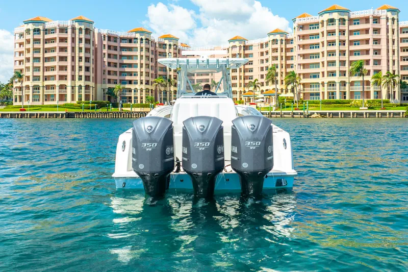  Yacht Photos Pics Invincible 39 boat with triple engines on water, luxury buildings in background, 2016 model.