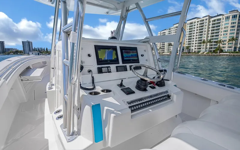  Yacht Photos Pics Helm of 2016 Invincible 39 boat with modern navigation equipment, docked near waterfront buildings.