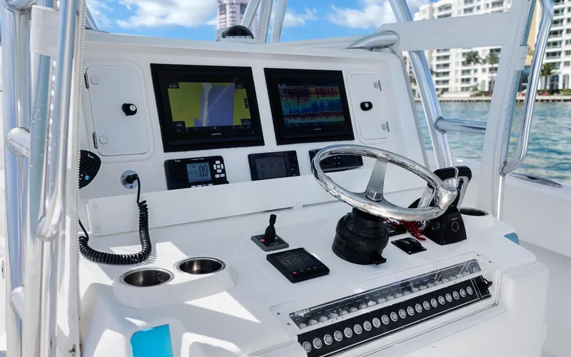  Yacht Photos Pics Control panel of a 2016 Invincible 39 boat with navigation screens and steering wheel.