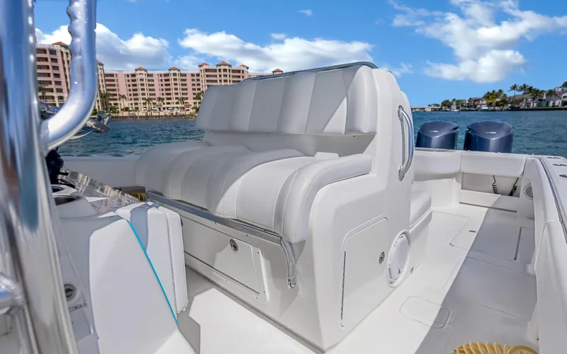  Yacht Photos Pics 2016 Invincible 39 boat interior with white seating, ocean view, and coastal buildings in the background.