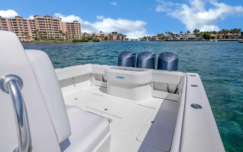  Yacht Photos Pics 2016 Invincible 39 boat on water, with cityscape and palm trees in background.
