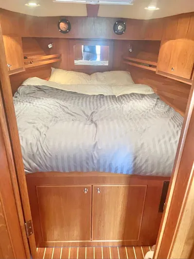  Yacht Photos Pics Cozy cabin interior of 2007 Coastal Craft 36 Cruiser with wood finish and comfortable bedding.