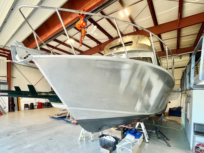  Yacht Photos Pics 2007 Coastal Craft 36 Cruiser in a warehouse, showcasing its sleek aluminum hull.