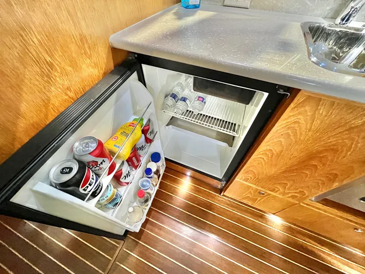  Yacht Photos Pics Mini fridge in 2007 Coastal Craft 36 Cruiser, stocked with drinks, on wooden floor.