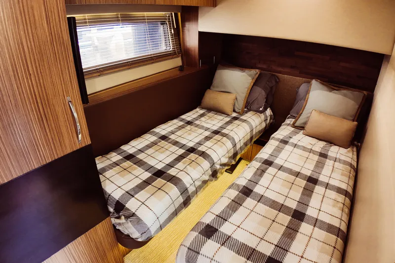 Incognito Yacht Photos Pics 2016 Sea Ray L590 Fly cabin with twin beds, plaid bedding, and wooden interior.