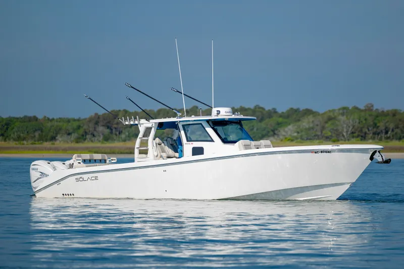  Yacht Photos Pics 2022 Solace 41 CS boat on calm water with fishing rods, clear sky background.