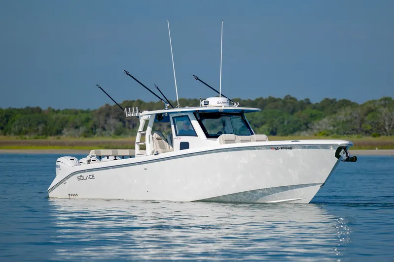  Yacht Photos Pics 2022 Solace 41 CS boat on calm water, featuring fishing rods and sleek design.